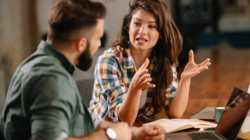 Woman speaking during mentoring session with man in quiet office space